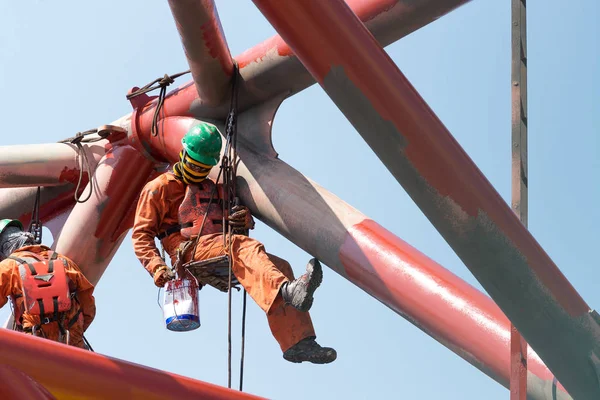 Рабочие, работающие на высоте для покраски нефтяной и газовой установки — стоковое фото