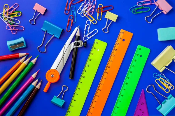 Ofis okul malzemelerini mavi arka plana yerleştir
