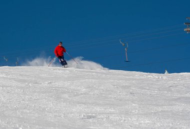 Yamaçtaki kayakçı, kışın tatil köyündeki adam.