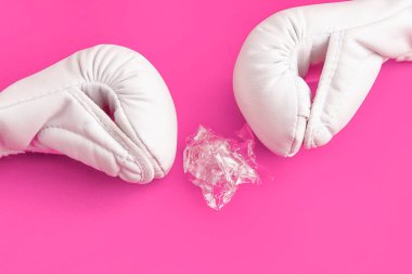 Pembe arka planda plastik çöplerle mücadele