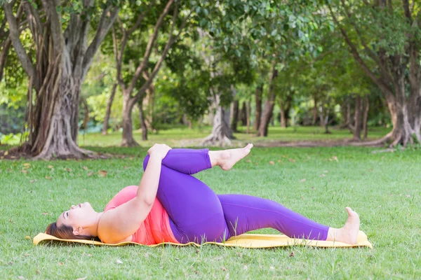 Yoga mat park yaparken güzel şişman kadın.
