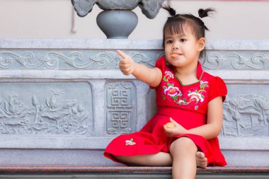 Çinli kızın balkon bir portakal yeme yakın çekim.