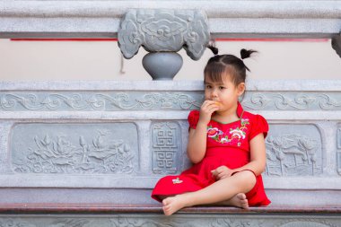 Çinli kızın balkon bir portakal yeme yakın çekim.
