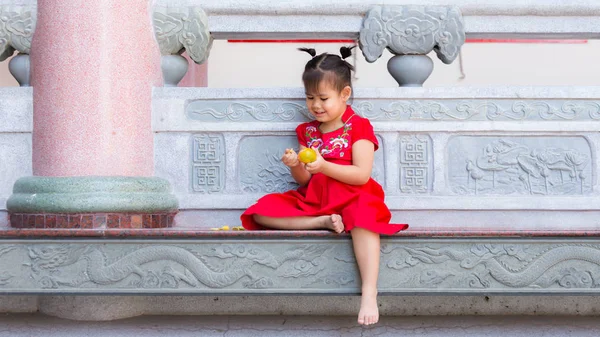 Close up of Chinese girl peeling an orange at balcony. — Stock Photo, Image
