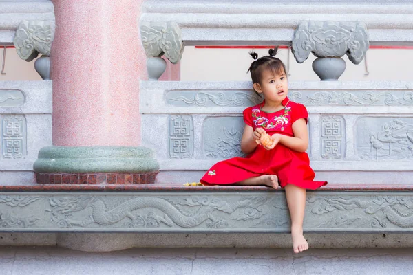 Close up de menina chinesa descascando uma laranja na varanda . — Fotografia de Stock