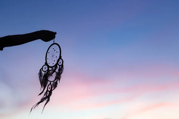 Silhouette de Dream Catchers tenir dans l'air pendant le coucher du soleil pe — Photo