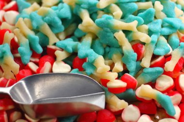 Çok renkli marmelat tatlısı, mavi, kırmızı, beyaz ve şeker için metal kepçe.