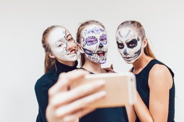Üç kız Halloween gidiyor, grimace selfie beyaz arka plan yapmak