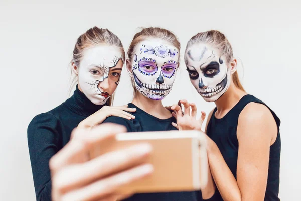 Три девушки собираются на Хэллоуин, гримаса сделать селфи белый фон — стоковое фото
