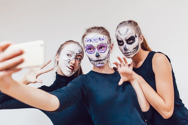 Tiga gadis yang akan Halloween, grimace membuat selfie latar belakang putih — Stok Foto