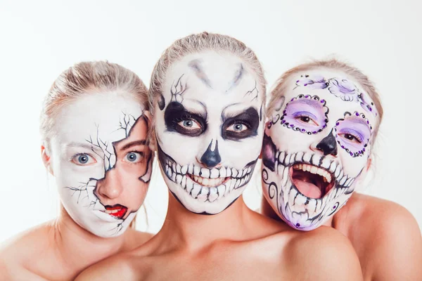 Três meninas com arte facial de Halloween no fundo branco — Fotografia de Stock