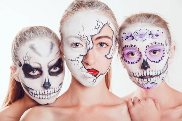 Três meninas com arte facial de Halloween no fundo branco — Fotografia de Stock