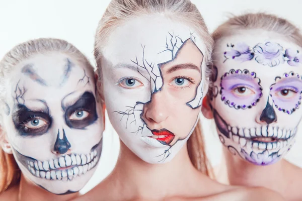 Três meninas com arte facial de Halloween no fundo branco — Fotografia de Stock