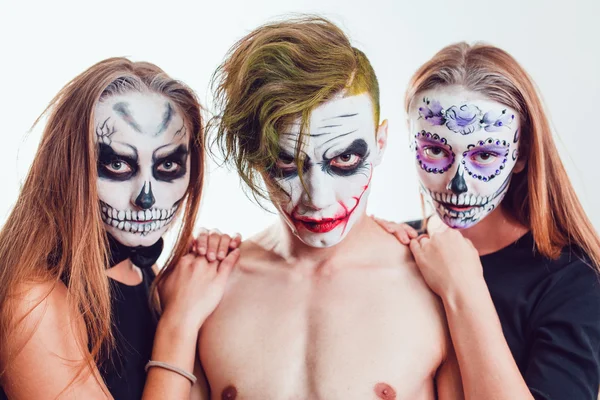 Duas meninas e um cara com arte facial de Halloween no fundo branco — Fotografia de Stock