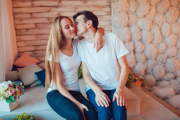 Giovane coppia innamorata seduta e uomo baciare ragazza sulla guancia — Foto Stock