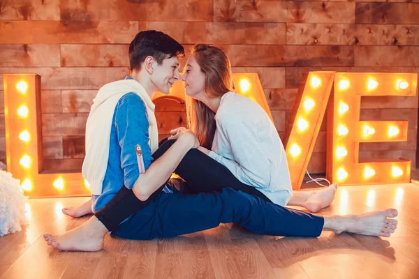 Junges Paar sitzt zu Hause auf dem Boden einander gegenüber und hält Händchen — Stockfoto