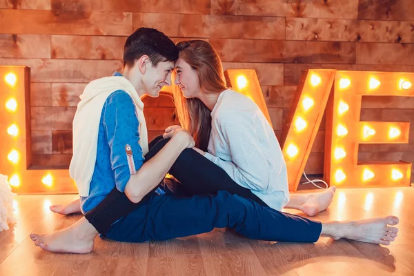 Junges Paar sitzt zu Hause auf dem Boden einander gegenüber und hält Händchen — Stockfoto