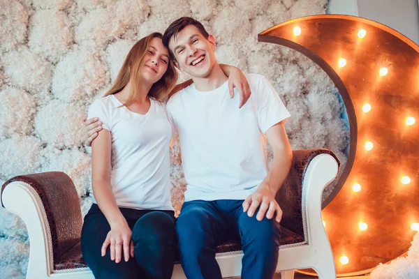 Молодая пара сидит обнимаясь дома — стоковое фото