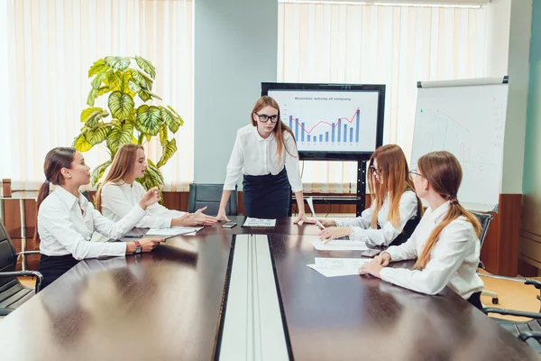 Vrouwelijke baas doet een beroep op de werknemers aan de tafel — Stockfoto