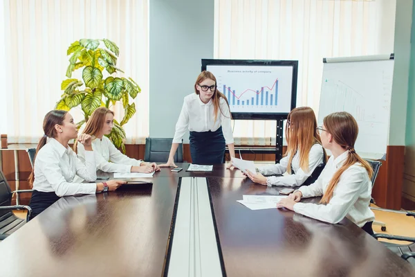 Vrouwelijke baas doet een beroep op de werknemers aan de tafel — Stockfoto