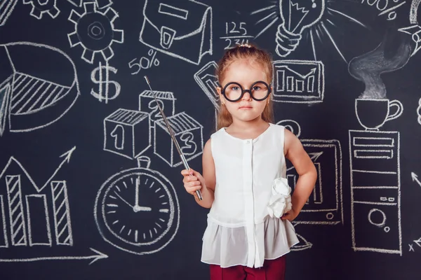 La niña inteligente en gafas sosteniendo un puntero sobre fondo oscuro con imagen de negocios o de la escuela —  Fotos de Stock