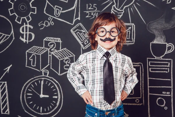Μικρό αγόρι ως επιχειρηματίας ή δάσκαλος με μουστάκι και γυαλιά που στέκονται σε ένα σκοτεινό μοτίβο φόντου. Φορώντας πουκάμισο, γραβάτα — Φωτογραφία Αρχείου