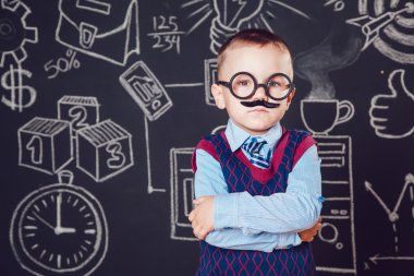 Bıyıklı ve gözlüklü işadamı ya da öğretmen olarak küçük çocuk ellerini koyu bir arka plan deseni üzerine katlanmış duruyor