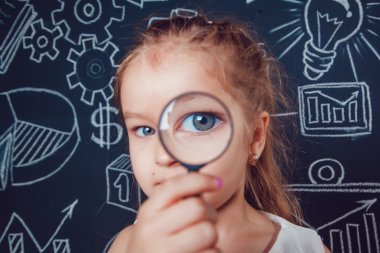 Küçük kız desenli koyu arka plan üzerinde büyüteç aracılığıyla arıyor. yakın çekim