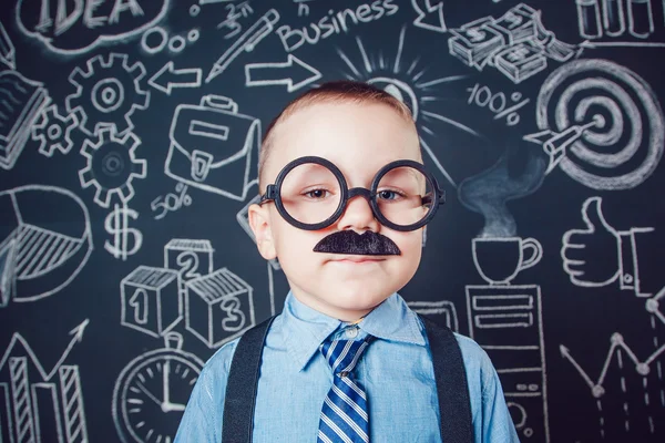 Little boy as businessman or teacher with mustache and glasses standing on dark background pattern. Wearing shirt, tie. close-up — Stock Photo, Image