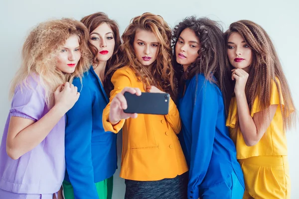 Divat lányok világos ruhát, hogy selfie. Gyönyörű nők szakmai smink és őrült frizurája, felső fehér háttér. — Stock Fotó