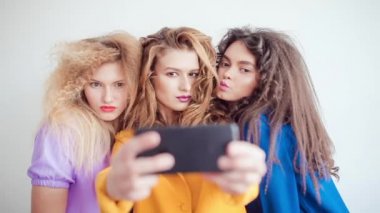 Profesyonel makyaj ve çılgın saç stili ile kız moda, beyaz arka plan üzerinde selfie olun.