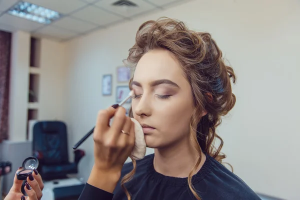 Maquillaje artista haciendo maquillaje de ojos profesional de mujer joven — Foto de Stock