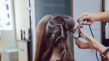 Profesyonel saç maşası güzellik Studio'yu kullanarak genç kadının saç stilisti yapar