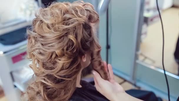Cabeleireiro faz penteado profissional de mulher jovem no estúdio de beleza — Vídeo de Stock