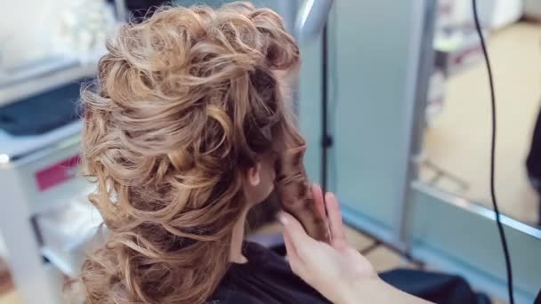 Hair stylist fa acconciatura professionale di giovane donna in studio di bellezza — Video Stock