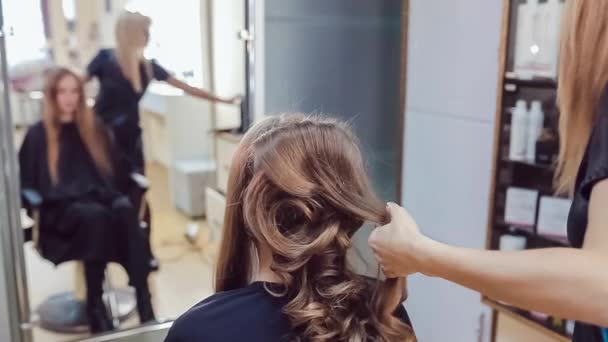 Στυλίστας μαλλιά κάνει επαγγελματικό χτένισμα νεαρή γυναίκα στο στούντιο ομορφιάς — Αρχείο Βίντεο