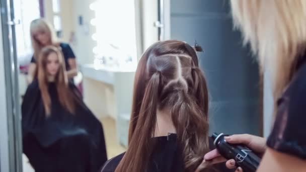 Haarstylist maakt professionele kapsel van jonge vrouw in de schoonheidssalon — Stockvideo