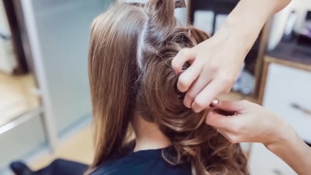 Peluquero hace peinado profesional de mujer joven en estudio de belleza — Vídeo de stock