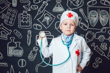 Mutlu küçük çocuk sthetoscope desenli koyu arka plan üzerinde tutan bir doktor gibi