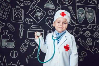Mutlu küçük çocuk sthetoscope desenli koyu arka plan üzerinde tutan bir doktor gibi