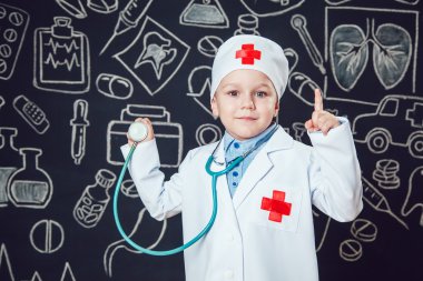 Mutlu küçük çocuk sthetoscope desenli koyu arka plan üzerinde tutan bir doktor gibi