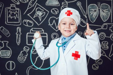 Mutlu küçük çocuk sthetoscope desenli koyu arka plan üzerinde tutan bir doktor gibi