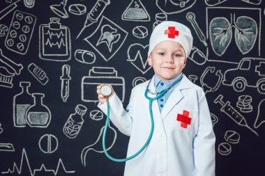 Mutlu küçük çocuk sthetoscope desenli koyu arka plan üzerinde tutan bir doktor gibi