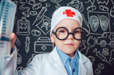 Mutlu küçük çocuk bir doktor desenli koyu arka plan üzerinde şırınga tutarak bardaklarda gibi