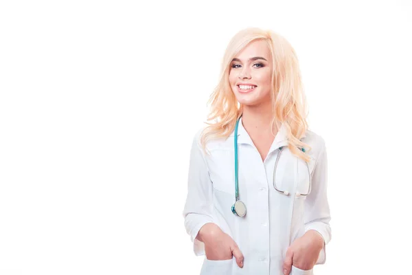 Mulher loira bonita médico com estetoscópio em pé sobre fundo branco . — Fotografia de Stock