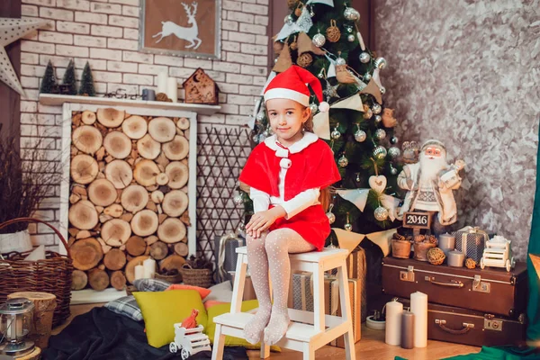 Petite fille habillée en Père Noël assis dans la décoration de Noël. Nouvel An . — Photo