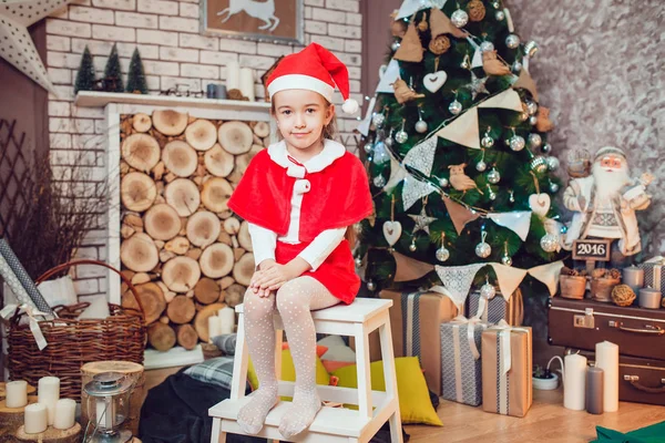 Petite fille habillée en Père Noël assis dans la décoration de Noël. Nouvel An . — Photo