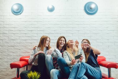 Güzel kız kanepede oturan ve eğlenceli hosteli