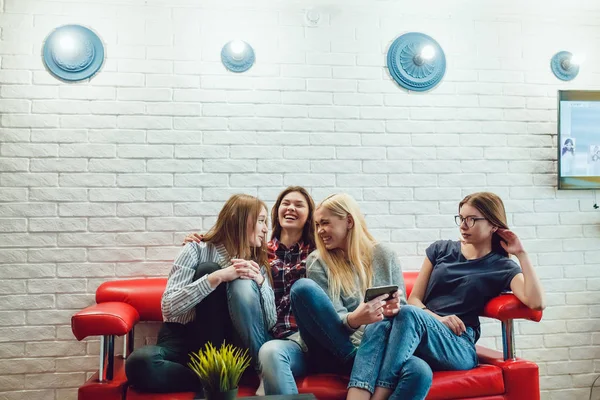 Schöne Mädchen sitzen auf der Couch und haben Spaß im Hostel — Stockfoto