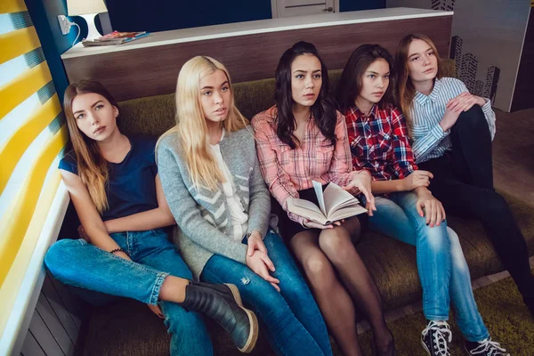 Gadis-gadis cantik duduk di sofa, bersenang-senang dan membaca buku di Hostel — Stok Foto